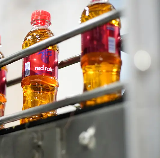 Close-up of Red Rain bottle on bottling line