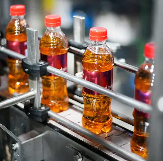 Red Rain bottles moving along conveyor belt