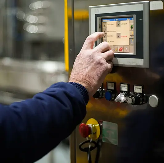 Technician hand navigating control screen on production line